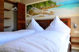 two beds in a room with a painting on the wall at Typ A Ferienhaus - Kailua in Pelzerhaken