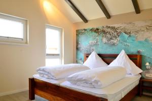 a bedroom with two beds and a painting on the wall at Typ A Ferienhaus - Kailua in Pelzerhaken