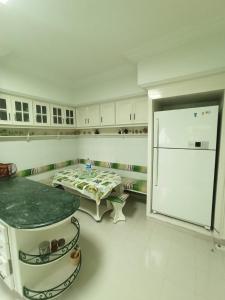 a kitchen with a refrigerator and a table in it at Dar jemaa in Nabeul