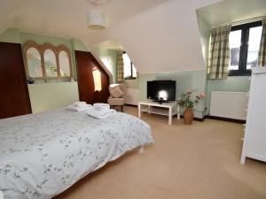 a bedroom with a large bed and a tv at 2 Bed in Winfrith Newburgh DC018 in Winfrith Newburgh