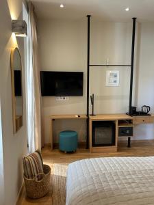 a bedroom with a bed and a desk and a tv at Living Yard Acropolis in Athens