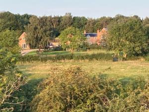 a large house in the middle of a field at Hen House: Private annexe on stunning farm in Melton Mowbray