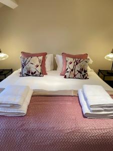 a large bed with two pillows on top of it at Picturesque Thameside Apartment in Henley on Thames