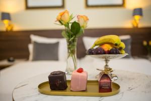 a table with a tray of fruit and a plate of chocolate at Private Comfort STEPHANSPLATZ - SELF CHECK IN in Vienna