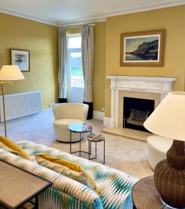 a living room with a couch and a fireplace at Picturesque Thameside Apartment in Henley on Thames