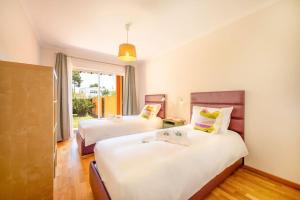 ein Hotelzimmer mit 2 Betten und einem Fenster in der Unterkunft Casa do Jardim- Aroeira in Aroeira