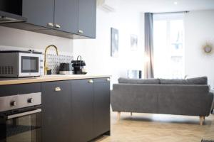 eine Küche und ein Wohnzimmer mit einem Sofa und einer Mikrowelle in der Unterkunft Appartement luxueux proche Arc-de-Triomphe - 4P in Paris