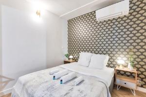 een slaapkamer met een bed met witte lakens en kussens bij Appartement luxueux proche Arc-de-Triomphe - 4P in Parijs