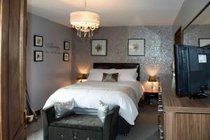 ein Schlafzimmer mit einem großen Bett und einem Fernseher in der Unterkunft 4 Bed Luxury Family Home In The Heart Of Narberth in Pembrokeshire