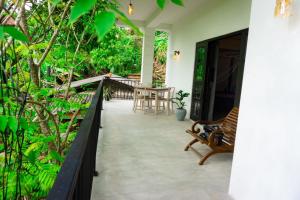a porch of a house with a bench and a table at Mountain Relax Inn in Weligama
