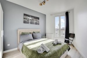 een slaapkamer met een bed met twee handdoeken erop bij Appartement Suite 43 aux Portes de Paris in Aubervilliers