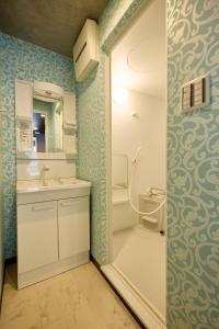 a bathroom with a sink and a toilet and a mirror at Hotel CABANA カバナ 宮古島 in Miyako Island