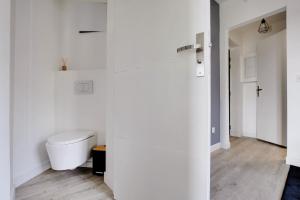 een witte badkamer met een toilet in een kamer bij Appartement Suite 43 aux Portes de Paris in Aubervilliers