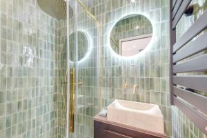 a bathroom with a sink and a mirror at Luxueuse maisonnette au coeur de Batignolles 17eme in Paris