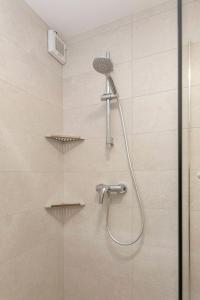 y baño con ducha con cabezal de ducha. en Apartma Naravni biser, en Brezje