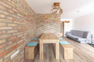 a living room with a wooden table and a brick wall at Apartma Naravni biser in Brezje