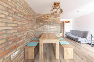 a living room with a wooden table and a brick wall at Apartma Naravni biser in Brezje +24 photos