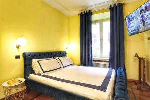 罗马Large and Charming Apartment in Trastevere by YourHost的一间卧室，墙上有一张床和一台电视