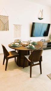 mesa de comedor con sillas y TV en Beautiful Star of the Caribbean - Apartment Estrella Dominicus Bayahibe, en La Laguna