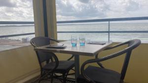 a table with two chairs and two wine glasses at Aux Trois Jean in Le Crotoy