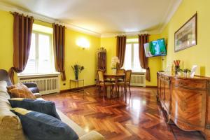 ein Wohnzimmer mit einem Sofa und einem Tisch in der Unterkunft Large and Charming Apartment in Trastevere by YourHost in Rom