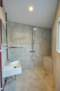 een badkamer met een wastafel en een douche bij Hotel CABANA カバナ 宮古島 in Miyako Island