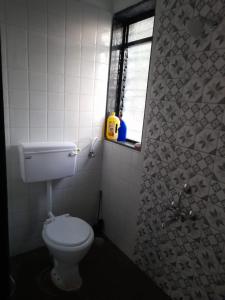 uma casa de banho com um WC branco e uma janela em Pathak Happy Trails, Dapoli em Dapoli
