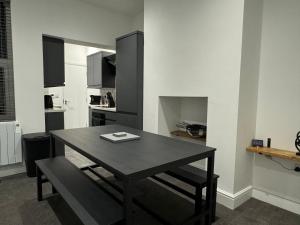 a kitchen with a wooden table and a dining room at Broadway Terrace with Hot tub in Kent