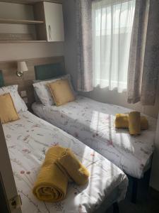 2 Betten mit Handtüchern in einem Schlafzimmer in der Unterkunft 19 The Maples in Grampound