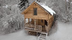 eine Holzhütte im Schnee mit schneebedeckten Bäumen in der Unterkunft Mestia Eco Huts 2 in Mestia