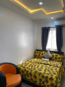 a bedroom with a yellow bed and a chair at Hope Residence hotel and suite in Lagos
