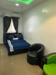 a bedroom with a blue bed and a chair at Hope Residence hotel and suite in Lagos
