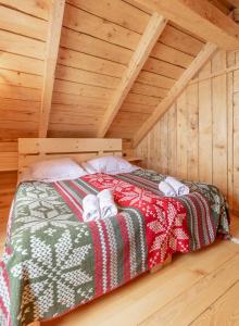 a bed in the attic of a wooden cabin at Mestia Eco Huts 2 in Mestia