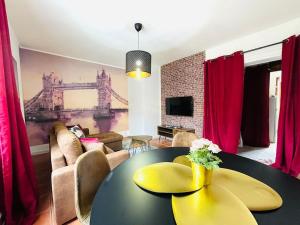 uma sala de estar com uma mesa amarela e um sofá em La Suite Shelby, T3 hypercentre em Beauvais