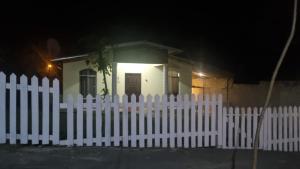 a white picket fence in front of a small house at La casa de la Gaviota in Siguatepeque