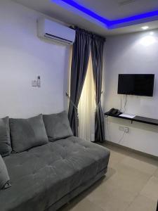 a living room with a couch and a flat screen tv at Hope Residence hotel and suite in Lagos