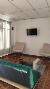 een woonkamer met een bank en een flatscreen-tv bij La casa de la Gaviota in Siguatepeque