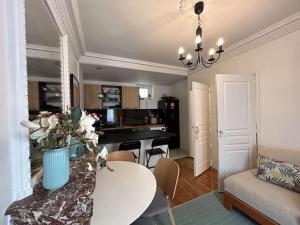 a living room with a table and a kitchen at Cosy Flat 2 BDR Arc de Triomphe Champs Elysées in Paris