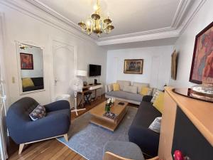 a living room with two couches and a table at Cosy Flat 2 BDR Arc de Triomphe Champs Elysées in Paris