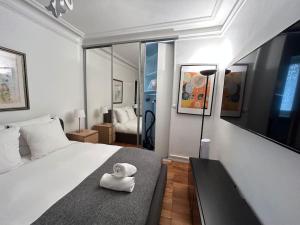 a bedroom with a bed with a towel on it at Cosy Flat 2 BDR Arc de Triomphe Champs Elysées in Paris