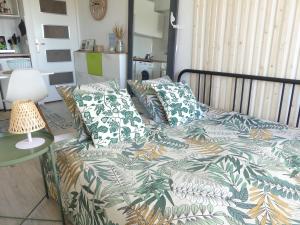 Schlafzimmer mit einem Bett mit einer grünen und weißen Bettdecke in der Unterkunft La Casita - Studio Confort avec Terrasse et Parking privé - La Grande Motte, Montpellier in La Grande-Motte