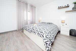Schlafzimmer mit einem Bett mit einer schwarzen und weißen Bettdecke in der Unterkunft Villa Pyeranch in Torrevieja