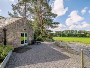 a stone building with a bench next to a field at 1 Bed in Sanquhar 89401 in Sanquhar