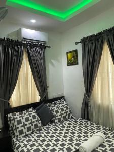 a bedroom with a black and white bed with curtains at Hope Residence hotel and suite in Lagos