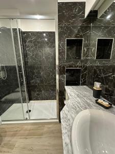 uma casa de banho com um chuveiro, uma banheira e um lavatório. em Evergreen Laguna Vain-Lezhe em Lezhë