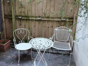 zwei Stühle und ein Tisch vor einem Zaun in der Unterkunft COOKS CABIN in Plymouth