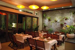 a restaurant with tables and chairs and a brick wall at Canary Beach Resort in Mui Ne