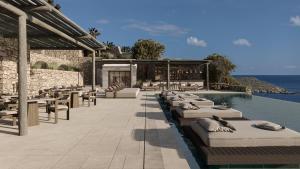 um resort com uma fila de espreguiçadeiras e uma piscina em Enigma Mykonos Hideaway Suites em Ornos