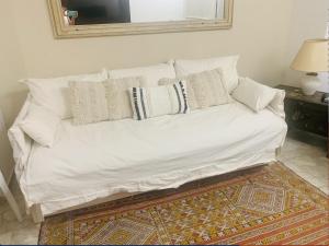 un sofá blanco con almohadas en una habitación en Divino departamento a estrenar en la península., en Punta del Este