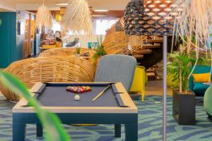 a pool table in the middle of a room with chairs at Mercure Toulouse Centre Saint-Georges in Toulouse